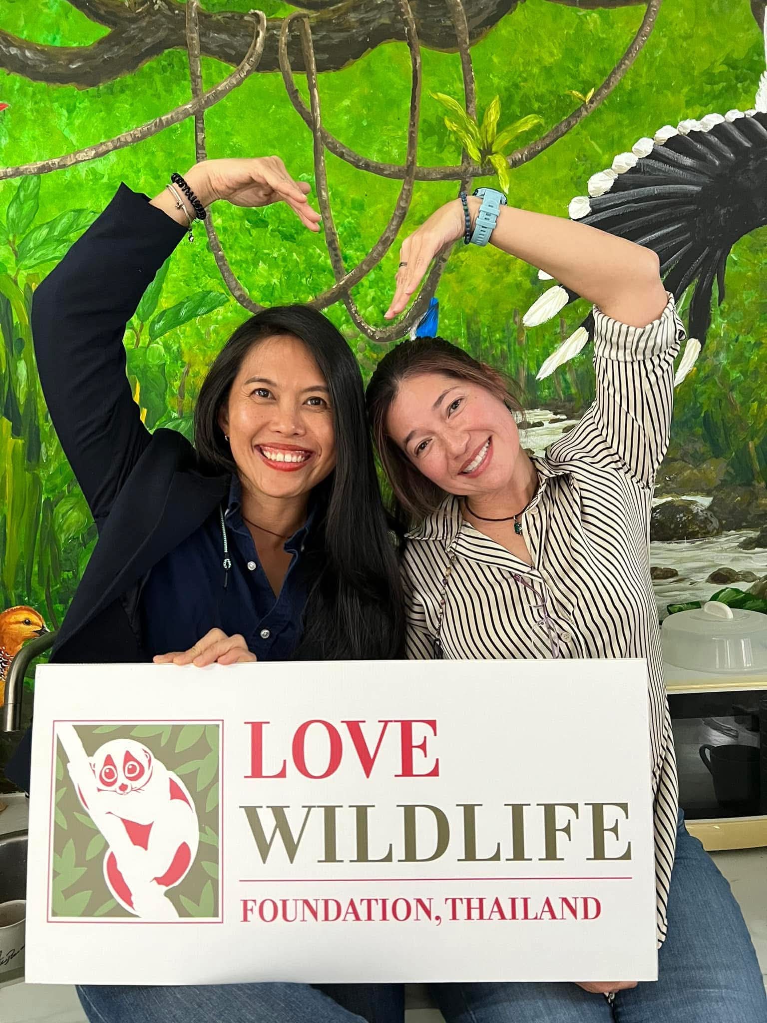Siriporn Sriaram and Nancy Gibson holding a Love Wildlife Foundation sign